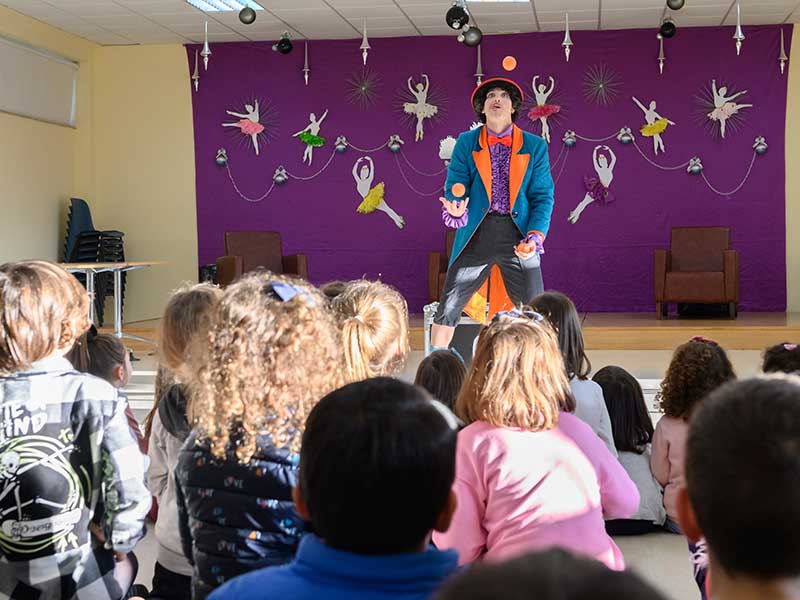 MeRe Clown facendo malabares frente a público infantil