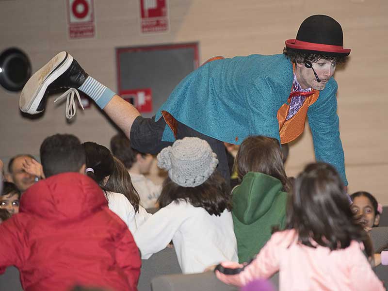 MeRe Clown facendo malabares frente a público infantil